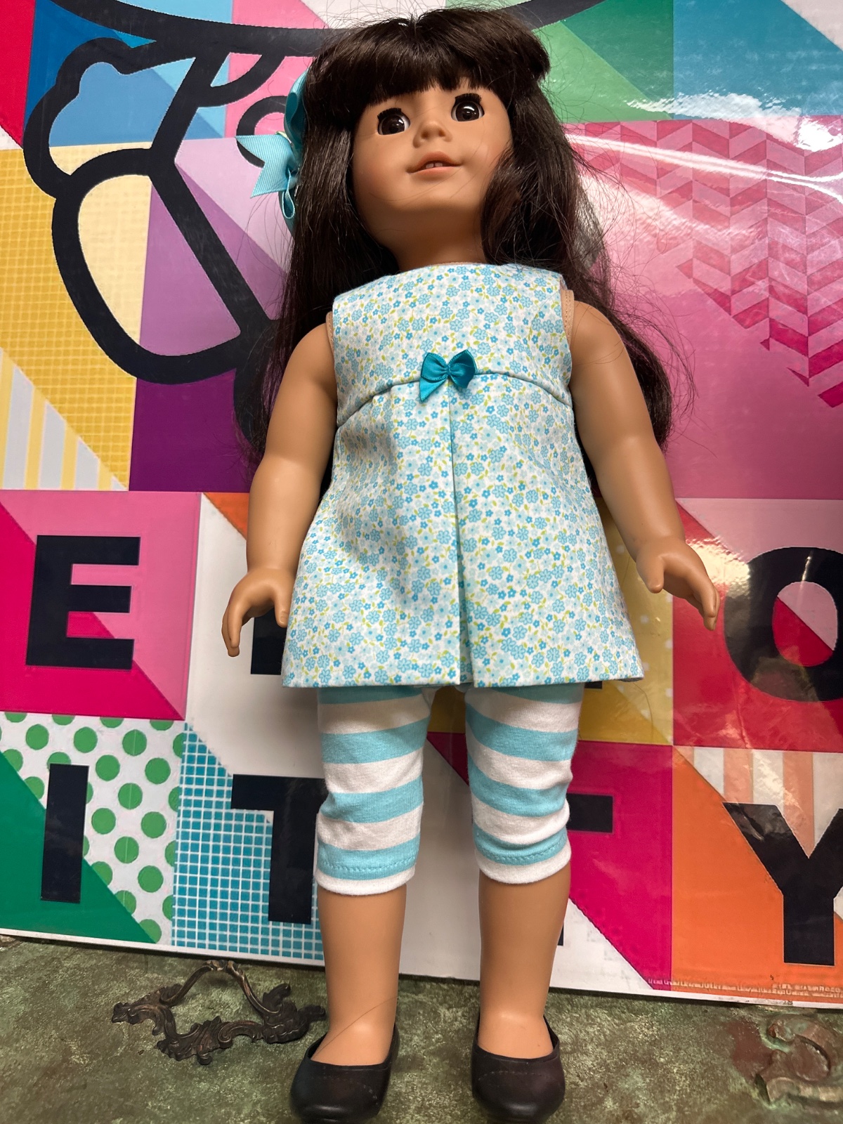Brunette Doll In Blue Floral Tunic And Striped Leggings